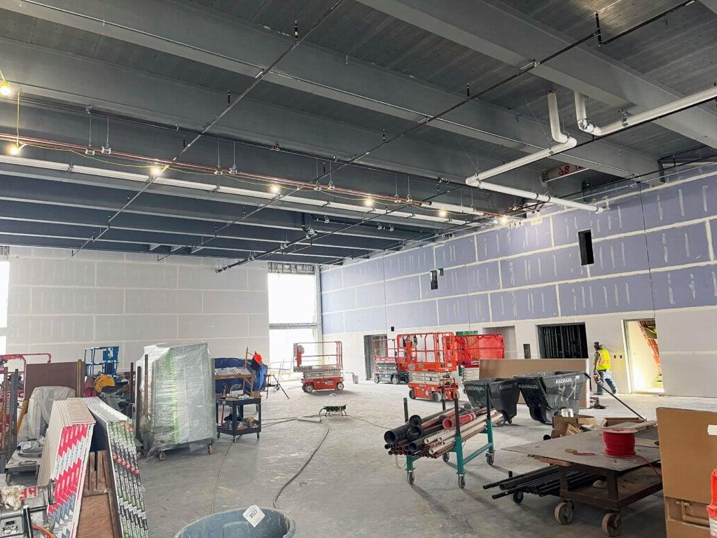 a large room with sprinkler piping in the ceiling and construction work in progress